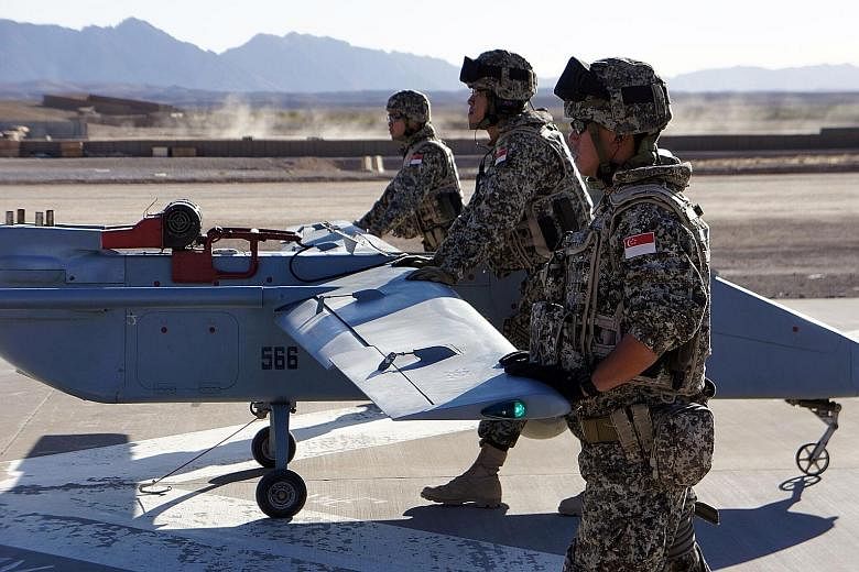 Singapore Armed Forces soldiers deploying an unmanned aerial vehicle as part of the UAV Task Group in Afghanistan in 2010. A robotics laboratory will be set up next month in the DSO National Laboratories to hone such technology.