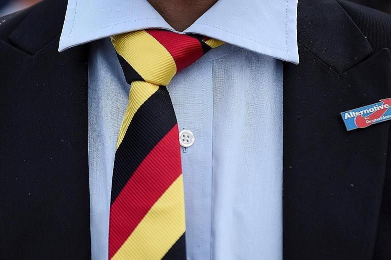 A man with a tie in Germany's national colours wearing a pin supporting the Alternative for Germany party. Recent polls show that support for the party has fallen significantly from a high of 15.5 per cent in December.