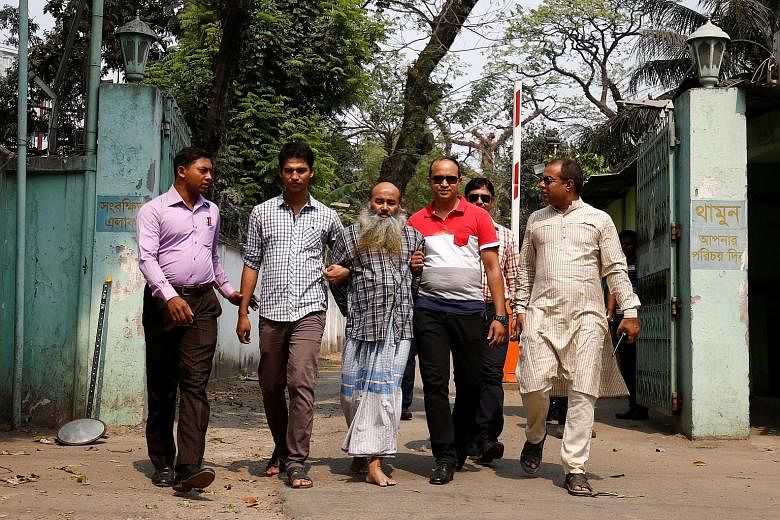 Security personnel with Maolana Abul Kashem, spiritual leader of the banned Jamayetul Mujahideen Bangladesh group, yesterday. Police say Kashem had met the alleged mastermind of the Dhaka cafe attack, Tamim Chowdhury, several times.
