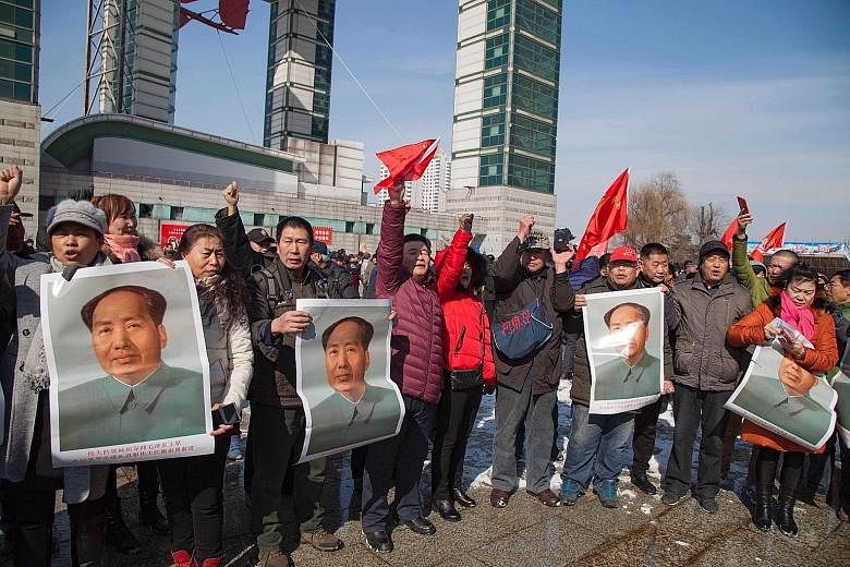 Residents in China's Jilin province with posters of the late communist leader Mao Zedong during a protest yesterday calling for a boycott of South Korean goods. South Korean companies are facing a backlash after the Seoul government secured land for 