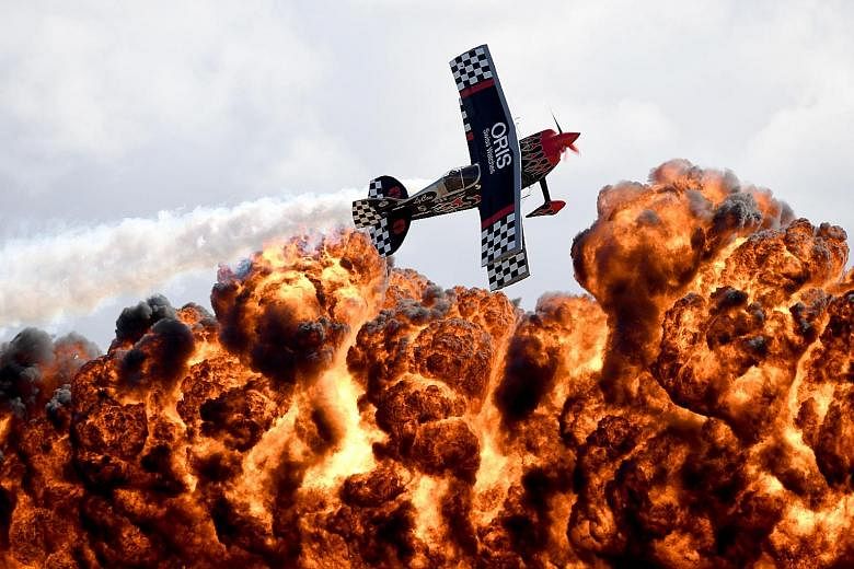 A member of the Tinstix of Dynamite aerobatics team flying above a wall of fire at the Australian International Airshow at Avalon Airfield, about 80km south-west of Melbourne, yesterday. The annual trade event saw 180,000 visitors over the three days