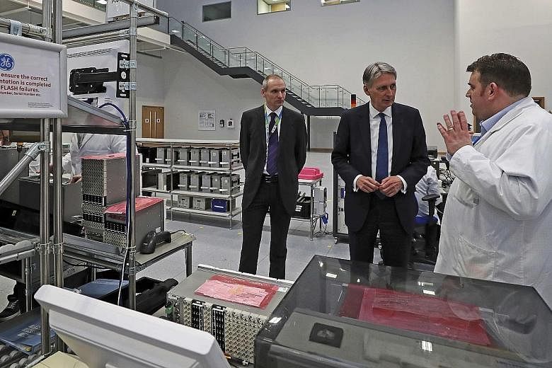 Finance Minister Philip Hammond visiting a General Electric factory in Stafford, Britain. He will present a major overhaul of the country's secondary education system in Parliament today.