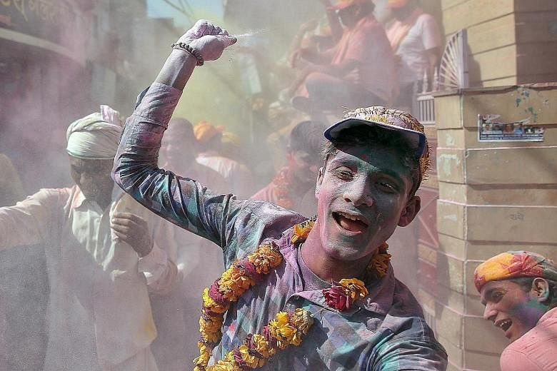 A man throwing coloured powder during Holi celebrations in the town of Barsana in the state of Uttar Pradesh in India on Monday. Holi is a Hindu festival that marks the arrival of spring. Known widely as the Festival of Colour, it takes place over tw