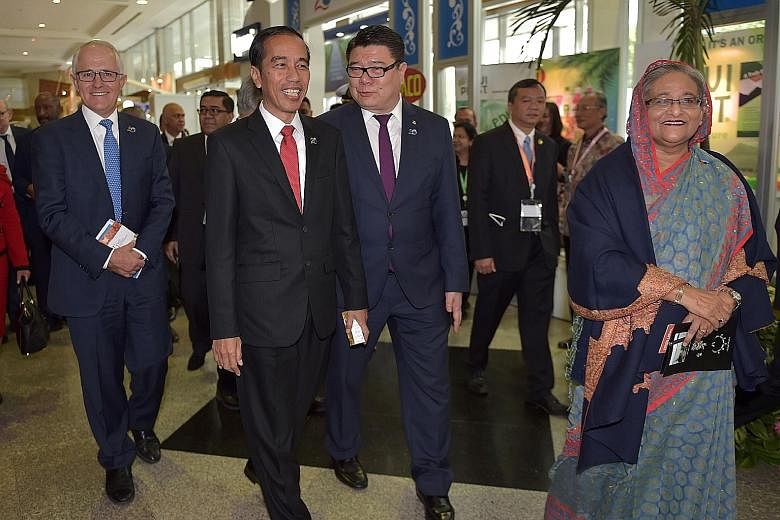 Both Mr Malcolm Turnbull and Mr Joko Widodo are wary of actions that could draw displeasure from Beijing. They are seen here at an exhibition on the sidelines of the Iora meeting. At far right is Bangladesh's Prime Minister Sheikh Hasina