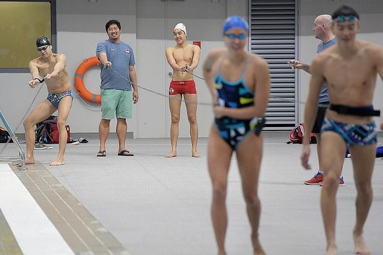 National Training Centre head coach Gary Tan (second from left) overseeing a training session for national swimmers yesterday. Under the new plan, the pool of national swimmers will be increased almost 10-fold to 200.