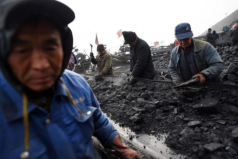 Chinese workers sort coal at a mine in Shanxi province. Coal imports tumbled to the lowest in nine months as demand weakened following the peak winter heating season. However, demand for commodities from iron ore to crude oil remains strong, resultin