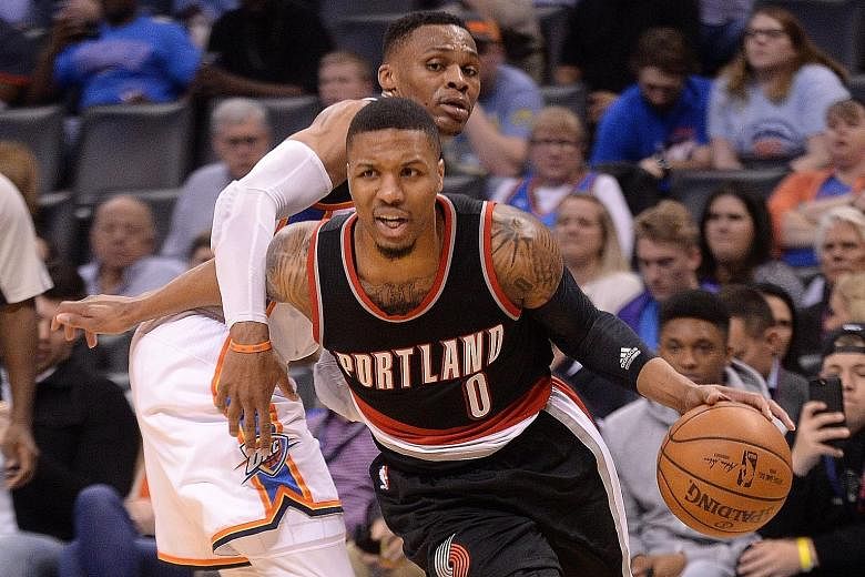 Portland guard Damian Lillard driving to the basket after evading a block by Oklahoma City guard Russell Westbrook. Seven Trail Blazers racked up double figures in their 126-121 win.