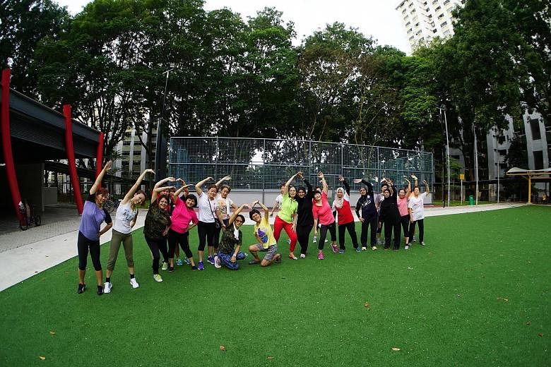 Housewife Suzana Hamzah (centre, in black) has been leading about 40 residents in morning exercises at a newly completed SIP project near her Boon Lay home.