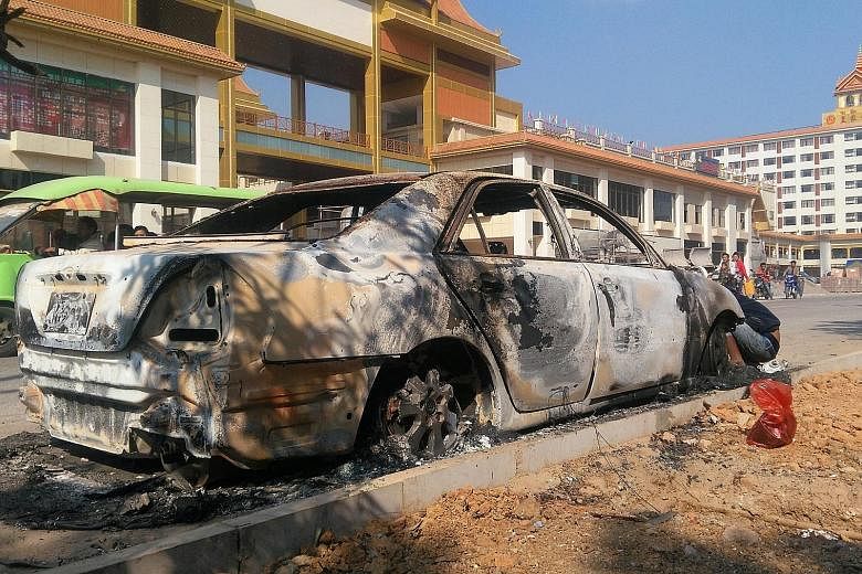 A burnt car in Laukkai, which bore the brunt of clashes between ethnic groups and security forces. About 30 people were killed this week in an attack by ethnic Chinese insurgents as thousands escaped to China.