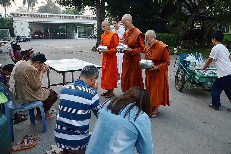 (Left) Female monks from Songdhammakalyani monastery blessing devotees after receiving alms. Dhammananda Bhikkuni (above), the abbess of the monastery, adjusting the position of one of her disciples during meditation practice. Female monk Ayya Visudd