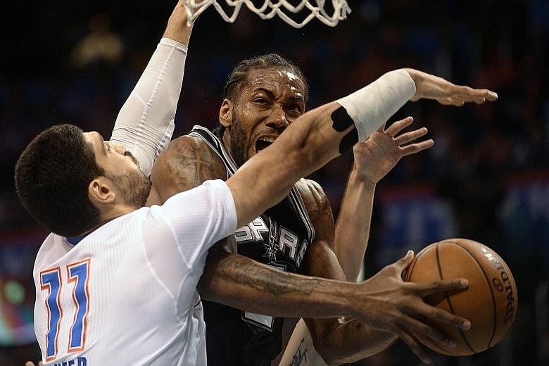 Spurs forward Kawhi Leonard (right) drives to the basket as Thunder centre Enes Kanter defends. Leonard scored a team-high 19 points.