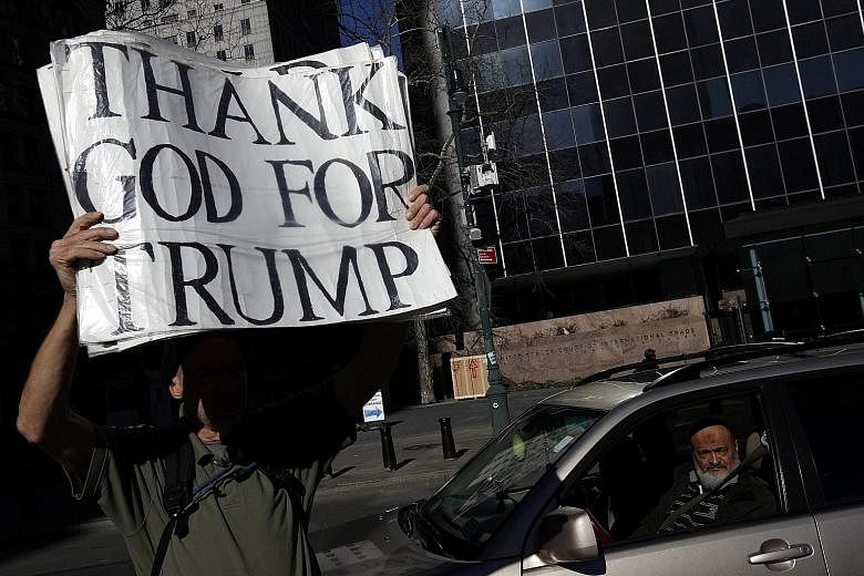 A Trump supporter holding up a sign at a protest held against deportation in New York on Thursday. Mr Trump has issued a new travel ban, applying to nationals from six mainly-Muslim countries, due to take effect on March 16.