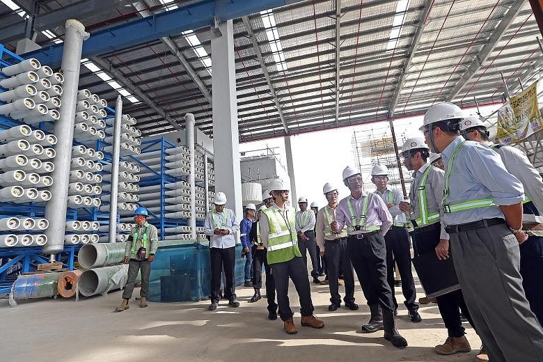 Minister for the Environment and Water Resources Masagos Zulkifli (in light pink shirt and high-cut boots) at the Tuas Desalination Plant 3 last month. In Parliament recently, Mr Masagos stressed the importance of pricing of water on sound economic princi