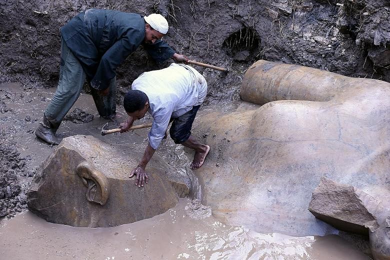 Workers preparing to lift parts of a statue for restoration after it was unearthed at Souq al-Khamis district in Cairo, Egypt, last Thursday. According to the Ministry of Antiquities, a German-Egyptian archaeological mission found two 19th dynasty ro