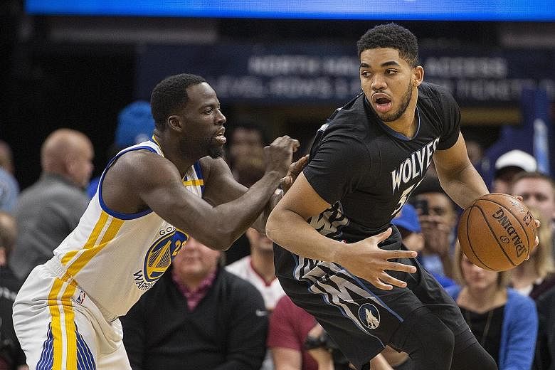 Timberwolves centre Karl-Anthony Towns protecting the ball from Warriors star Draymond Green in the NBA on Friday. Minnesota won 103-102.