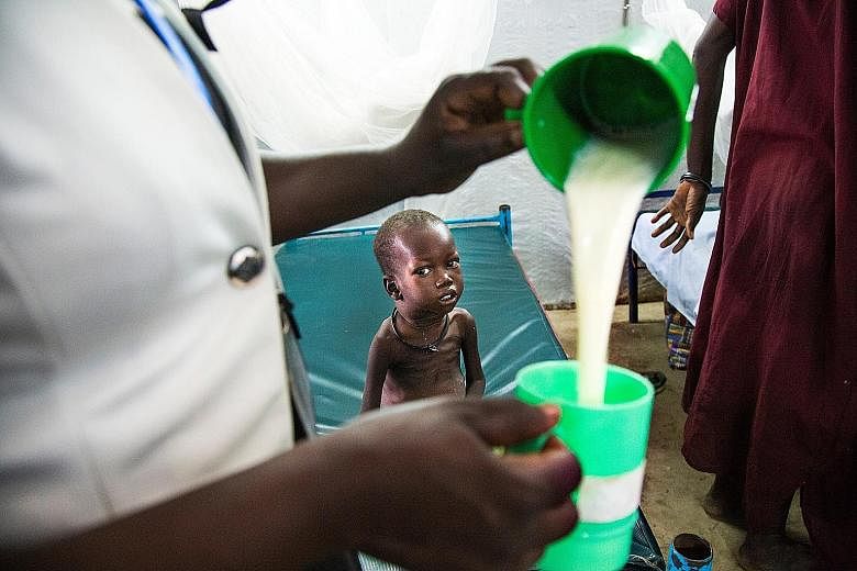 An internally displaced Somali woman holds her malnourished child fitted with a nasogastric tube inside a ward dedicated for diarrhoea patients at the Banadir hospital in Somalia's capital Mogadishu, on March 5. About 6.2 million people in the countr