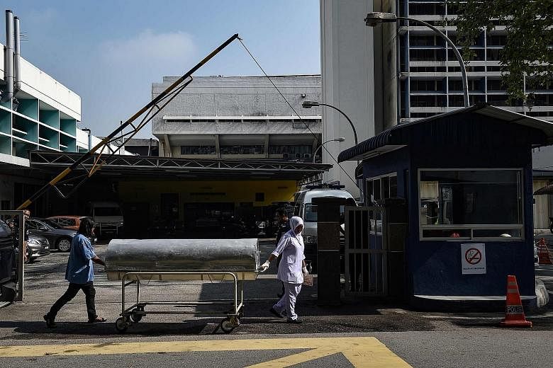 Hospital workers moving a body cart yesterday from Kuala Lumpur Hospital, where the body of Mr Kim Jong Nam lies. Malaysia said last Friday that it had positively identified Mr Kim's body.