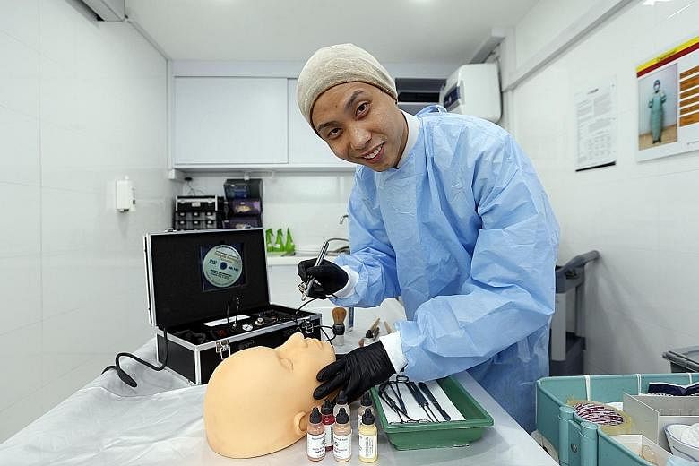 Mr Teo demonstrating how he uses an airbrush gun to apply liquid foundation on a face. His job involves mainly washing, embalming and dressing bodies before applying make-up.