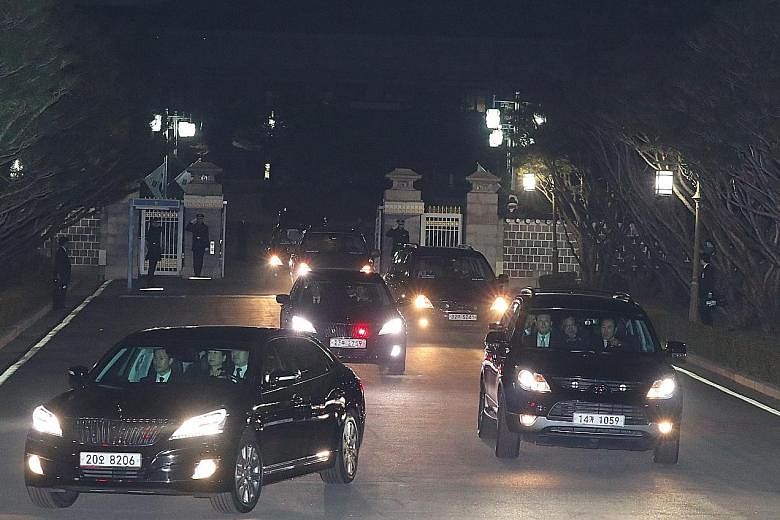 South Korea's impeached president Park Geun Hye (in car at left) being driven away from the presidential Blue House as she returned to her private residence in Seoul on Sunday, two days after the Constitutional Court's verdict confirming her removal 