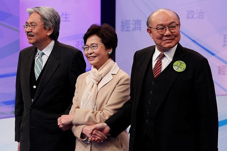 Chief executive candidates John Tsang (left), Carrie Lam and Woo Kwok Hing sharing the same stage for the first time last night to spar on political, economic and livelihood issues, with the hope of winning over public opinion.