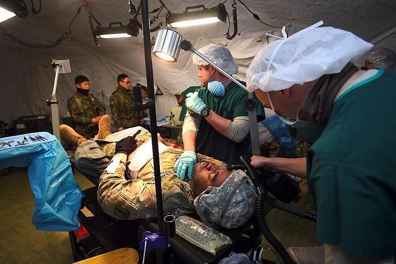 US medics during a joint mock evacuation as part of the annual military exercises known as Key Resolve and Foal Eagle at a South Korean Army hospital in Goyang, north-west of Seoul, yesterday. Pyongyang lobbed four ballistic missiles towards Japan la
