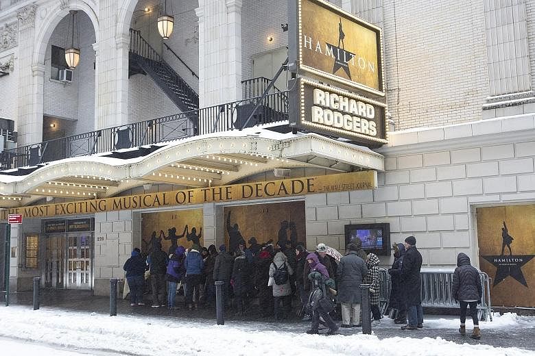 A line of people in New York on Tuesday, waiting for cancellation tickets to Broadway's Hamilton, a musical about the life of American founding father Alexander Hamilton. Expecting 0.6m of snow, New York City ended up with less than half that and lif