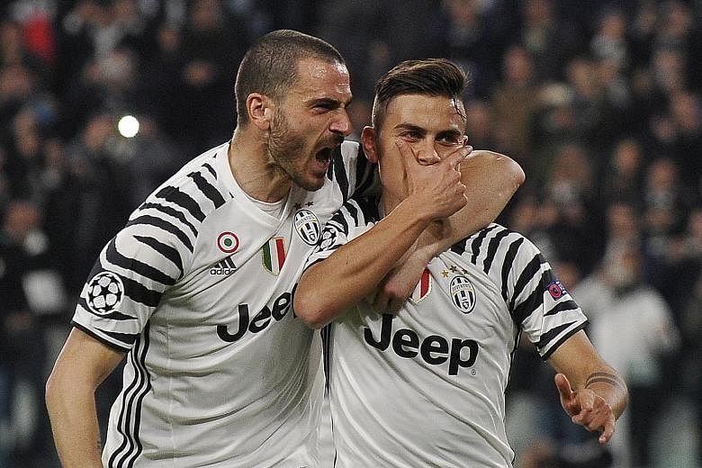 Juventus forward Paulo Dybala celebrates scoring the winner from the spot against Porto with Leonardo Bonucci.