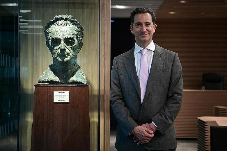 Dr Marshall at SMU's moot court with the bust of Mr Marshall, which is on loan to the university. The bust has been in the family since 1956, when it was sculpted by a London-based artist.