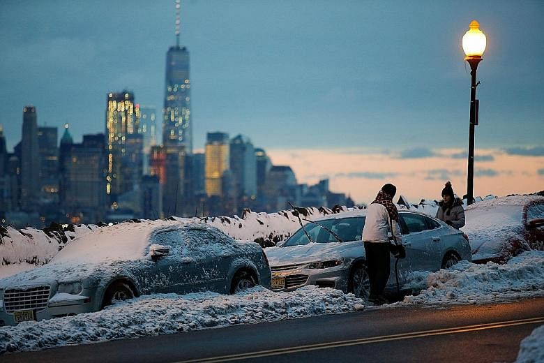 People clearing snow in Weehawken, New Jersey on Tuesday after a snowstorm.