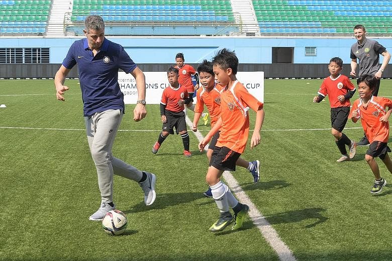 Former Inter Milan goalkeeper Francesco Toldo (left) and former Chelsea striker Tore Andre Flo (right) in a kickabout with children from local football training centres at Jalan Besar Stadium yesterday.
