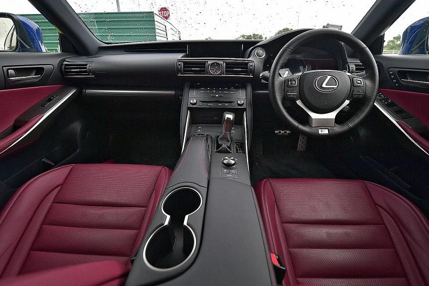 The Lexus IS Turbo is capable of manic manoeuvres with menacing-looking headlamps to match. Inside (below), the infotainment screen and the compartment on the centre armrest have been enlarged.