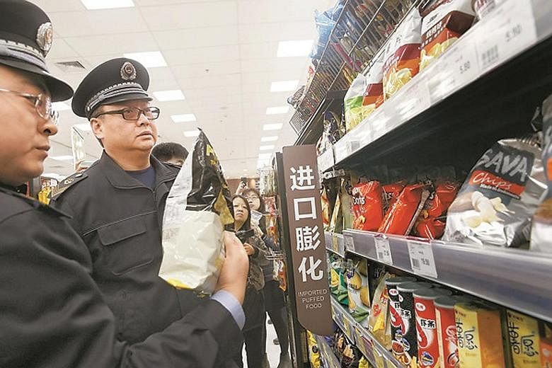 Officers from the Beijing Food and Drug Administration checking imported food at a supermarket on Thursday. In Beijing, major supermarkets and e-commerce platforms have started inspections following the CCTV report accusing Muji of selling contaminat