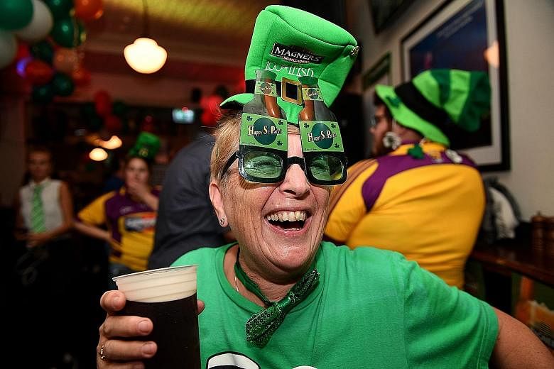 A woman celebrating St Patrick's Day at a hotel at The Rocks in Sydney, Australia, yesterday. St Patrick's Day is marked annually on March 17 to commemorate Saint Patrick, a patron saint of Ireland, and it is customary for revellers to wear green.