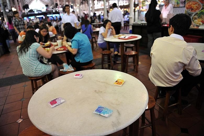 Packets of tissue paper being used to reserve a table at a hawker centre. Mr Ronald Lee says such a practice should be disallowed.