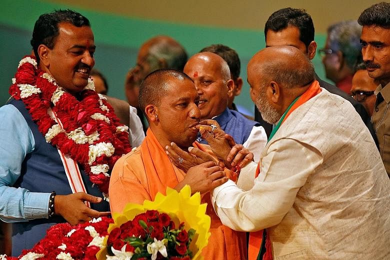 Mr Yogi Adityanath being offered sweets at a BJP legislative party meeting at the Uttar Pradesh capital of Lucknow last Saturday, after he was elected chief minister of the state. Analysts expect his appointment to test the strength of the party's co
