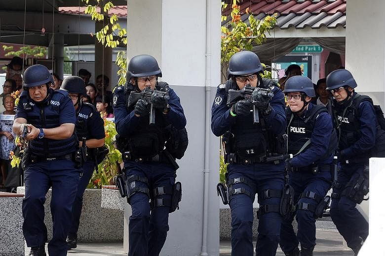 Home Team officers moving in on a coffee shop being attacked by armed "terrorists" yesterday, as part of an exercise on Emergency Preparedness Day in Teck Ghee.
