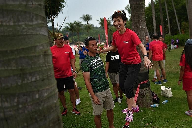 Above: Minister Fu slacklining at Sentosa. Like tightrope walking, slacklining involves balancing and walking on a line anchored on both sides above ground level. Left: National ultimate frisbee player Janssen Tan (in red) and former national player 