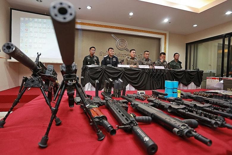 Police chief Chakthip Chaijinda (third from left) speaking to the media on Sunday. In the foreground are weapons seized from a house which police say used to be occupied by fugitive "red shirt" activist Ko Tee.