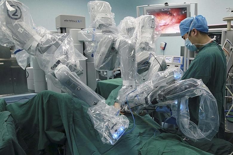 A surgeon using a robot to operate on a patient in Hefei, Anhui province. Increasingly, robots are being used for work demanding fine precision, such as operating inside the human body while being controlled remotely by a surgeon. Local staff are sti