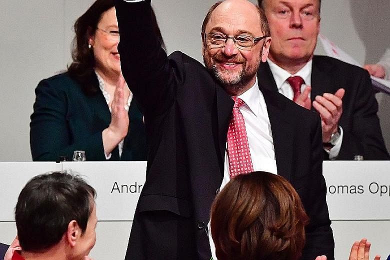 Mr Schulz acknowledging his victory after becoming the SPD leader on Sunday. He supports free education, more investment in nursing care and schools, and qualification programmes for the unemployed.