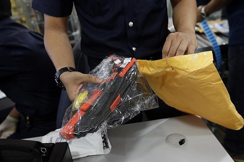 An Immigration and Checkpoints Authority (ICA) officer opened this package as it looked suspicious but it was found to contain only a toy gun. Singapore Post staff sorting letters and packages so that they can reach their recipients in Singapore. ICA