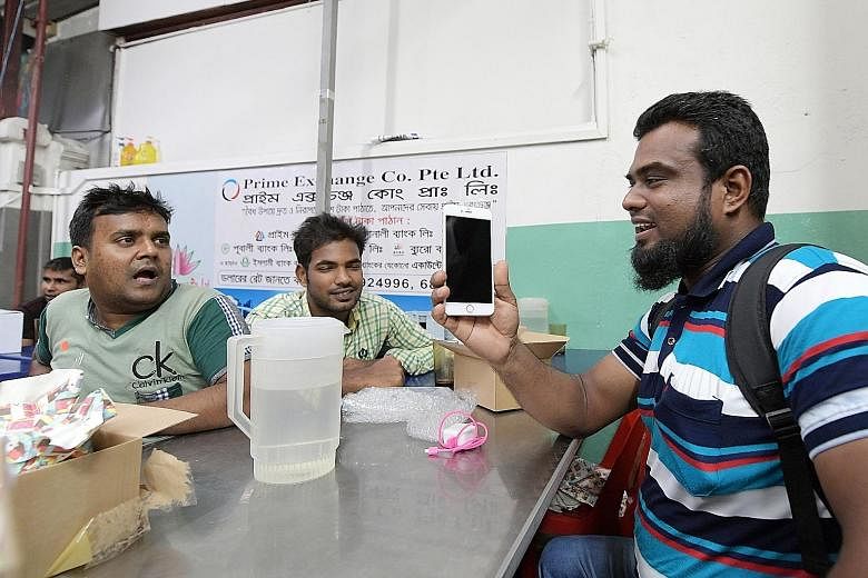 Mr Madbaryousuf with his iPhone 6 Plus at the phone giveaway last night. He was among 50-plus migrant workers who received upgraded phones, thanks to a campaign by Transient Workers Count Too.