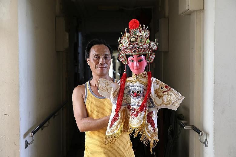 Mr Peter Chew, who leads Hainanese puppet troupe San Chun Long, with a puppet of Wu Song, an ancient Chinese character in novels. Mr Chew's troupe, which has been active since the 1920s, is one of only two such groups left in Singapore.