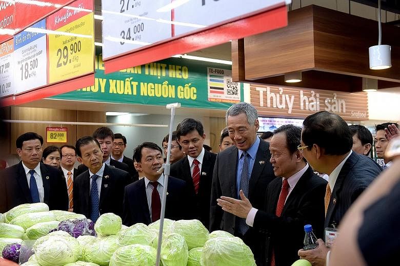 Prime Minister Lee Hsien Loong visiting SC VivoCity shopping mall in Ho Chi Minh City's Saigon South Place Complex yesterday. The complex, developed by Mapletree Investments, includes a new 17-storey office tower which was officially opened yesterday