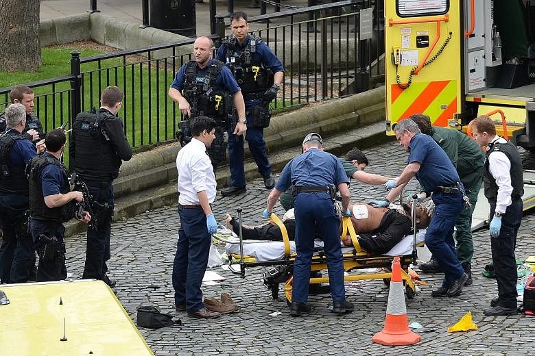 Emergency workers attending to the alleged assailant, who was shot by police after he reportedly made his way into the Parliament grounds and attacked an officer. Members of the public being taken to safety near Westminster Bridge, where eyewitnesses