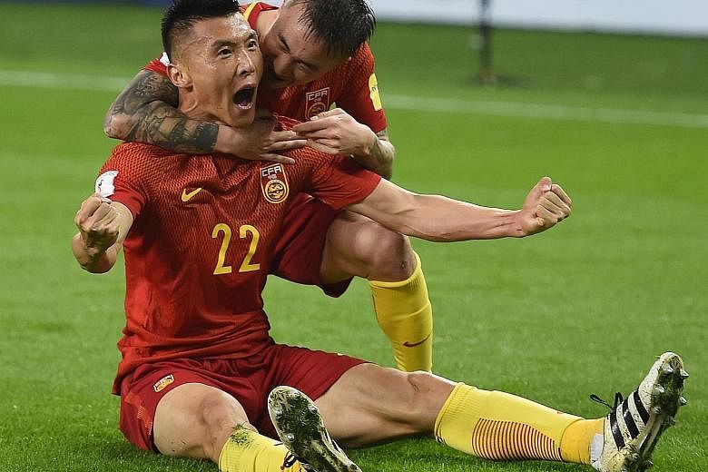 China's Yu Dabao celebrating his 34th-minute goal against South Korea with Wang Yongpo. The goal was the sole difference between both sides and a win against Syria in their next game could put China back in contention for a play-off spot.