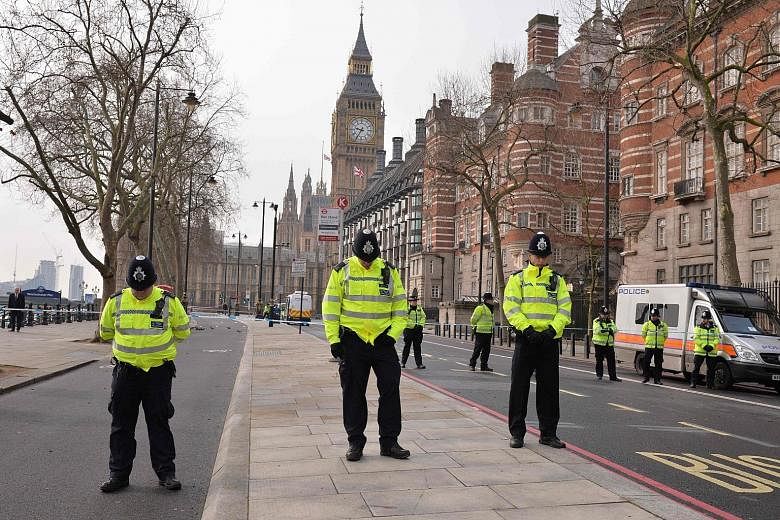 Police officers near Britain's Houses of Parliament joining in a minute of silence yesterday to commemorate the victims of Wednesday's terror attack.
