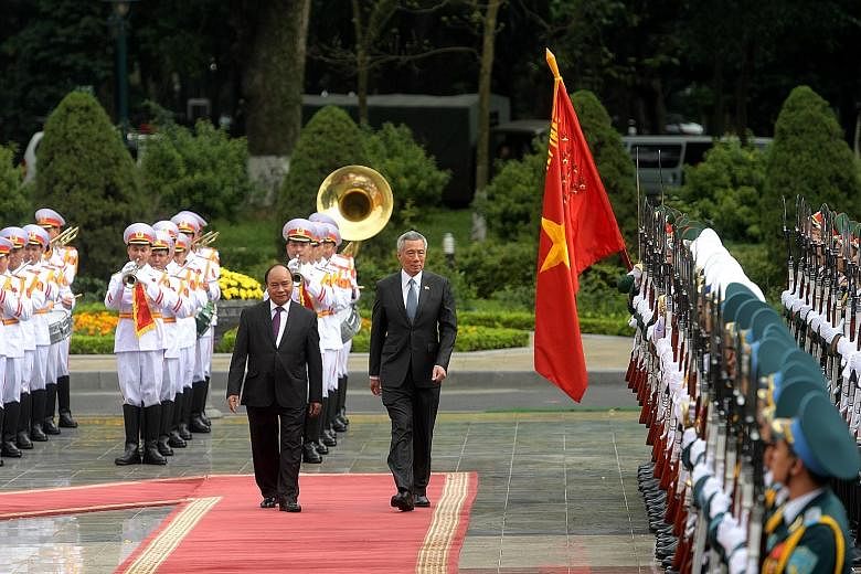 PM Lee being welcomed by Vietnamese PM Phuc at a ceremony in Hanoi's Presidential Palace yesterday.