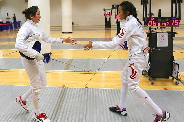 Singapore national junior fencer Kiria Tikanah Abdul Rahman (right) shaking the hand of her Singapore Sports School's opponent Michelle Lee. Kiria beat Lee 15-6 to win the Schools National A Division girls' individual epee event and will be confident