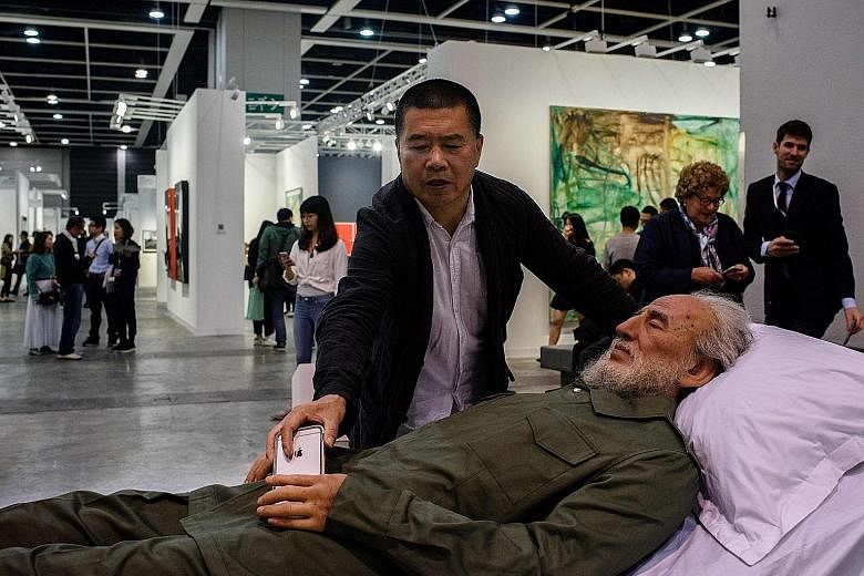 Chinese artist Shen Shaomin with a replica of former Cuban leader Fidel Castro at Art Basel in Hong Kong.